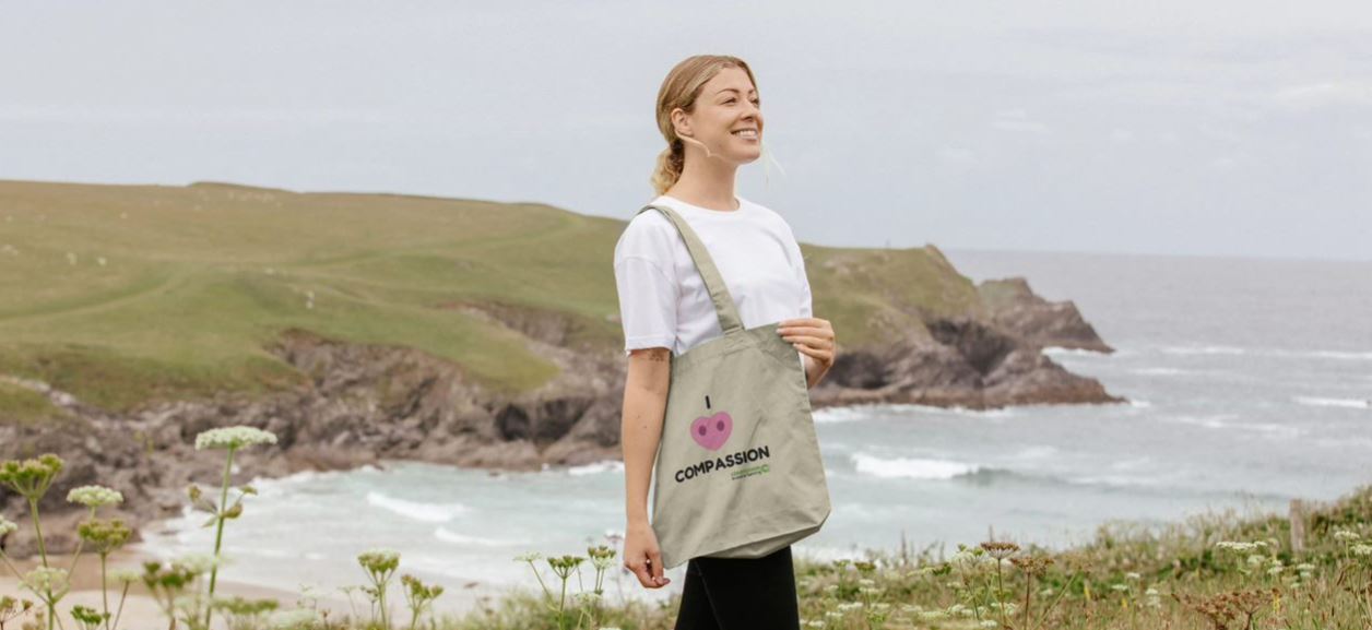 Female model with Compassion tote bag